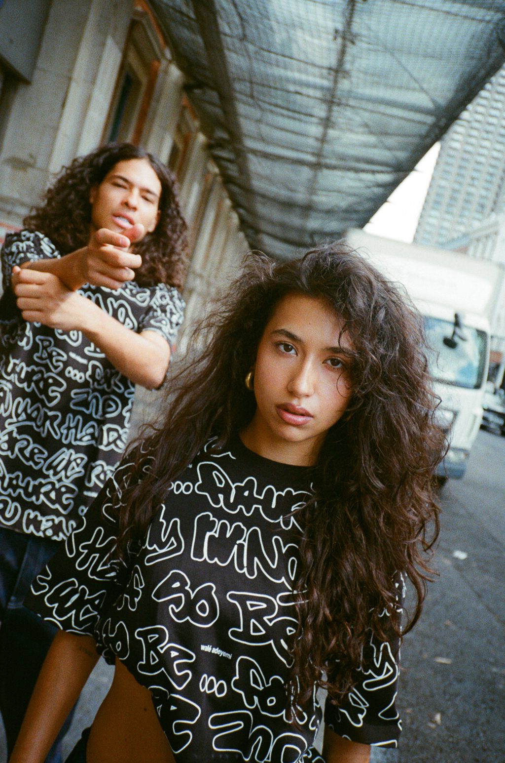 Two people in the AOP Graf T-shirt under a market canopy