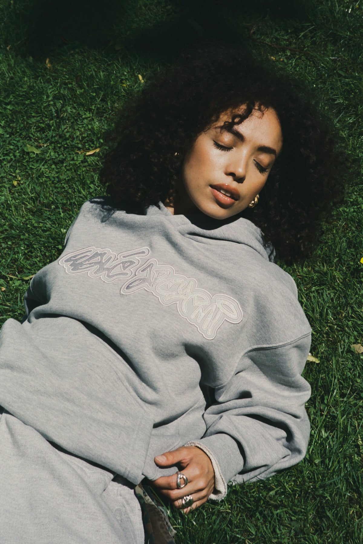 A woman wearing grey Wale Adeyemi logo hoodie