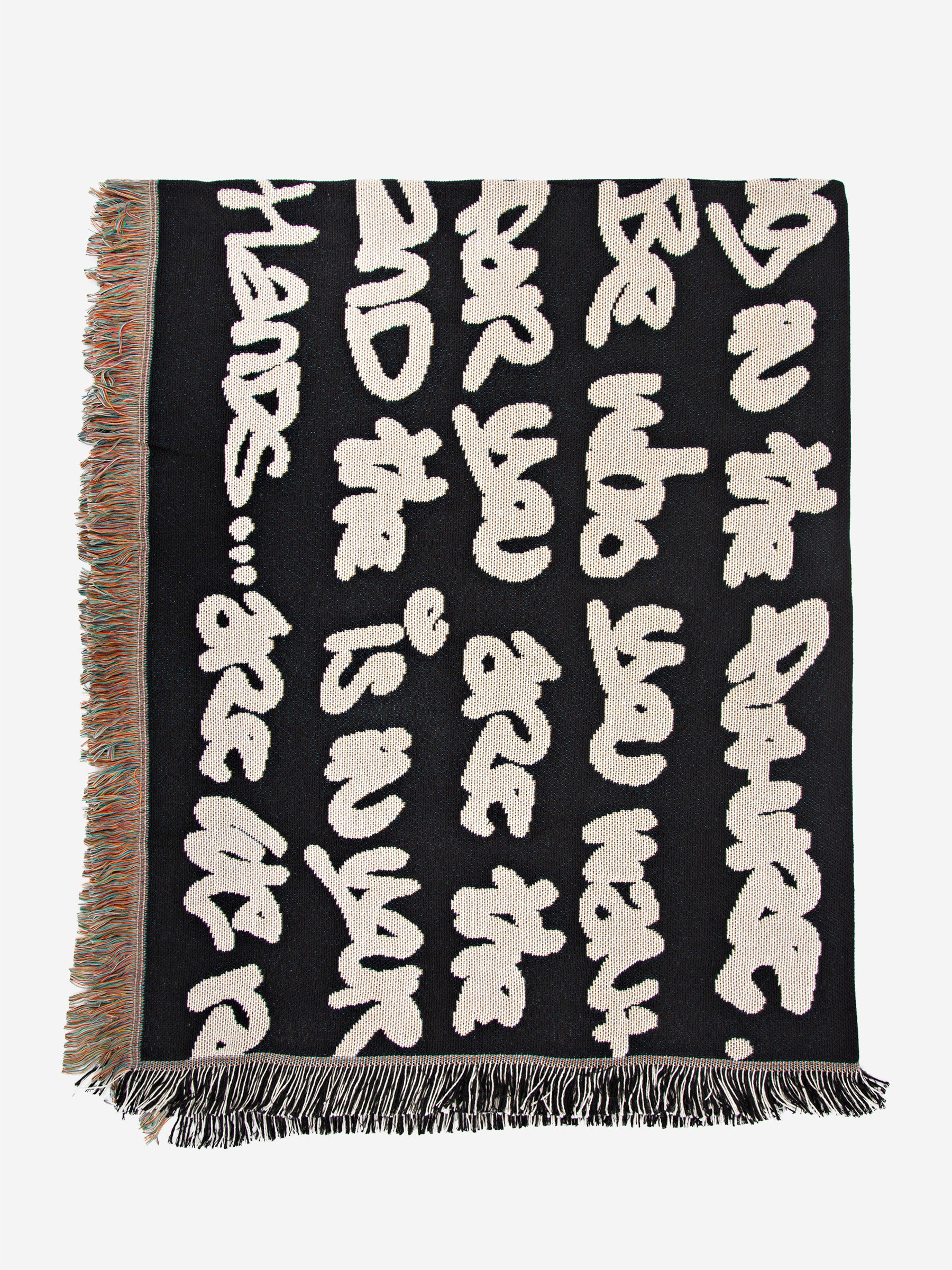 Wale Adeyemi woven throw blanket underside view showing graphic typography weave and fringed edges