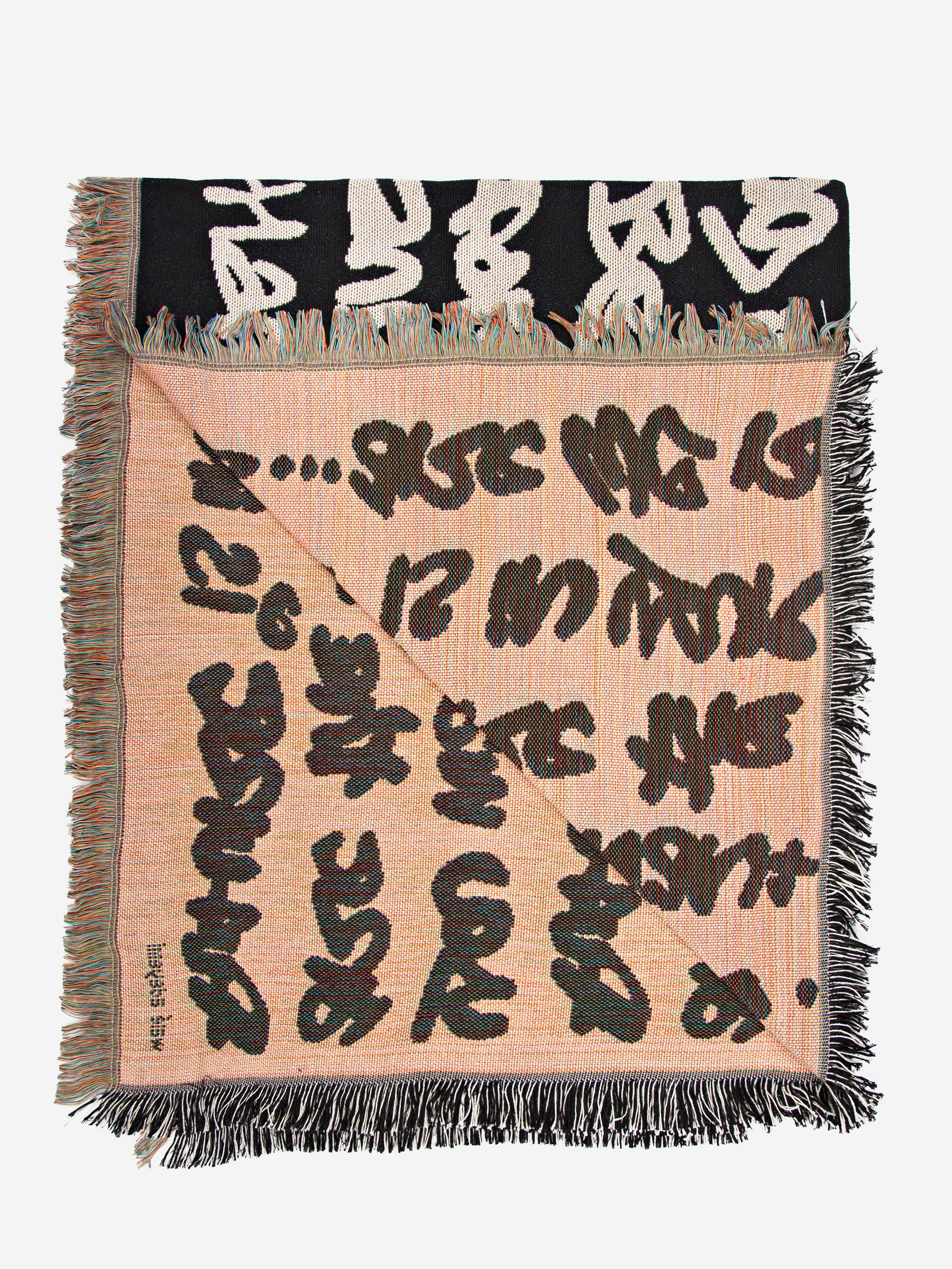 Wale Adeyemi woven throw blanket underside view showing graphic typography weave and fringed edges