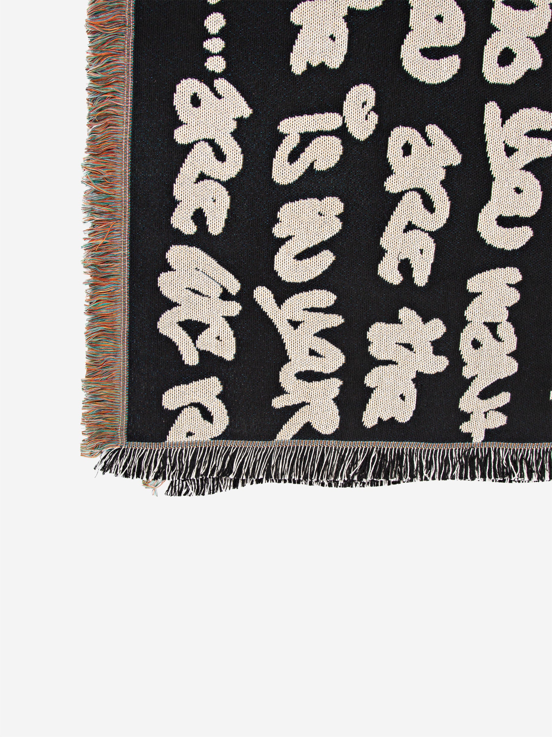 Wale Adeyemi woven throw blanket underside view showing graphic typography weave and fringed edges