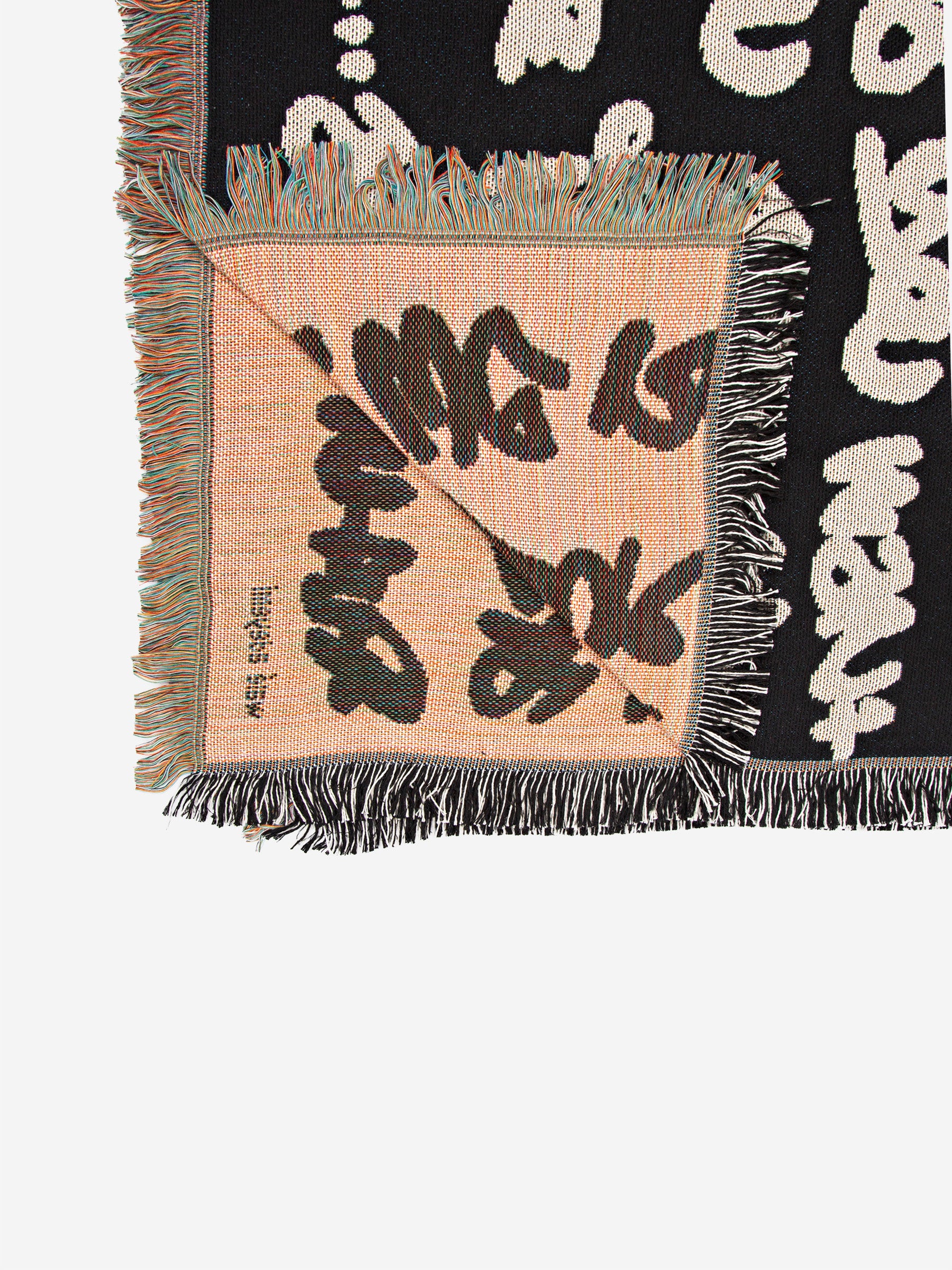 Wale Adeyemi woven throw blanket underside view showing graphic typography weave and fringed edges