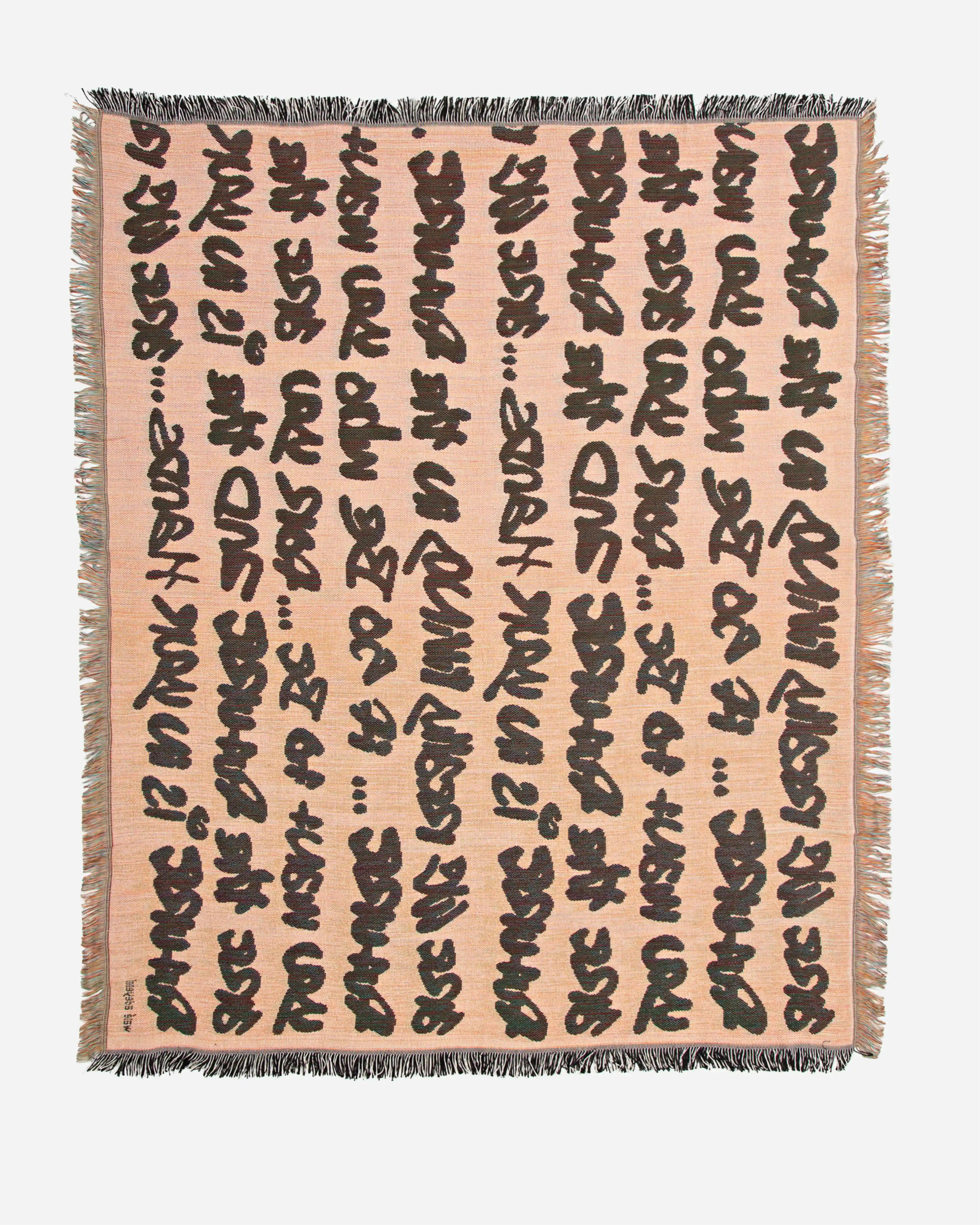 Full flat lay view of Walé Adeyemi woven throw blanket in peach beige with black typographic script and fringed border