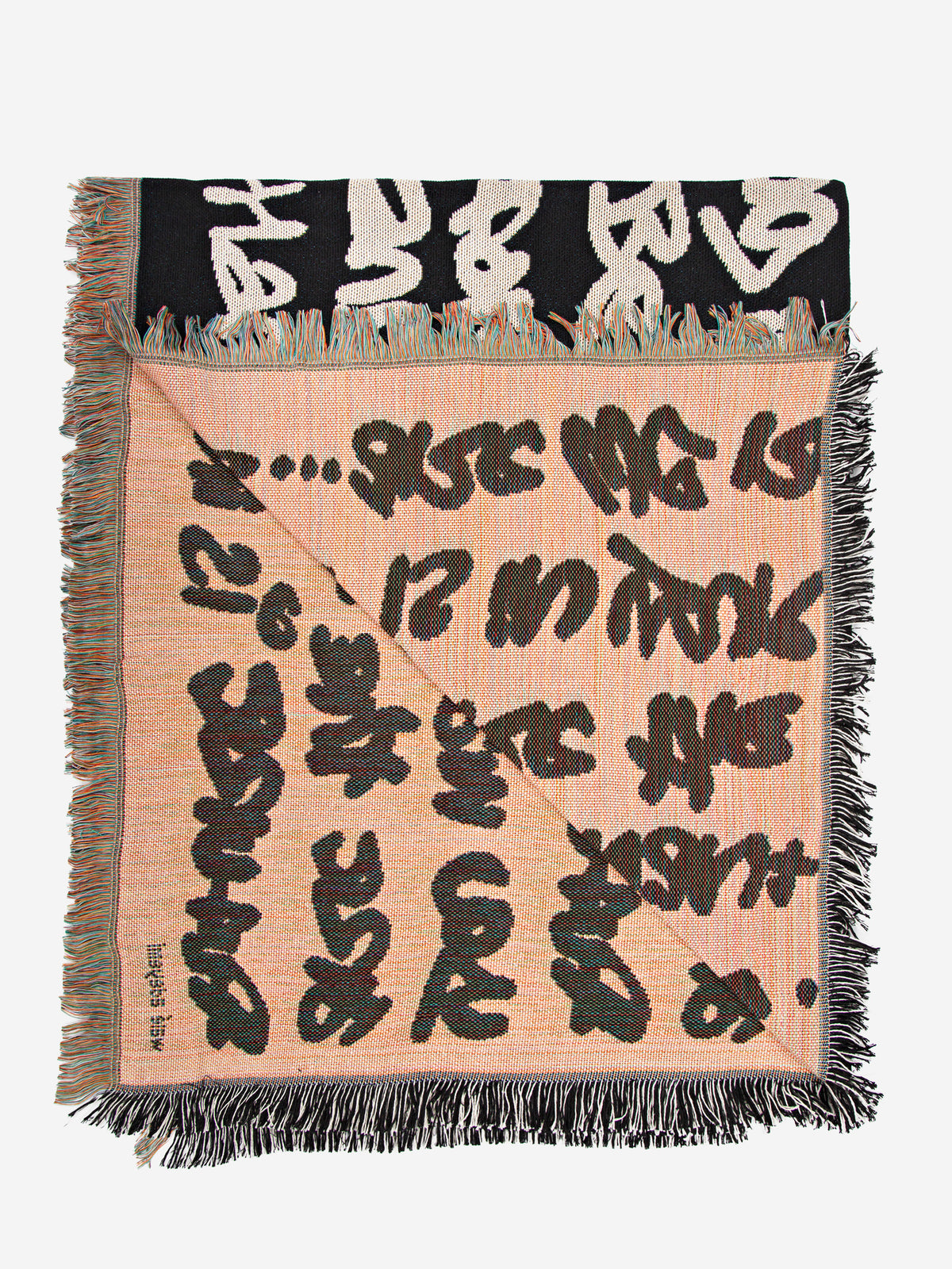 Walé Adeyemi woven throw blanket underside view showing graphic typography weave and fringed edges