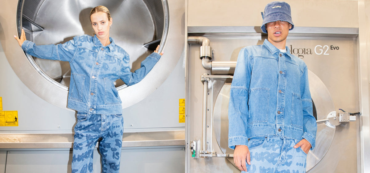 Models wearing blue denim jacket, graffiti-printed jeans and hat in the wash area banner image