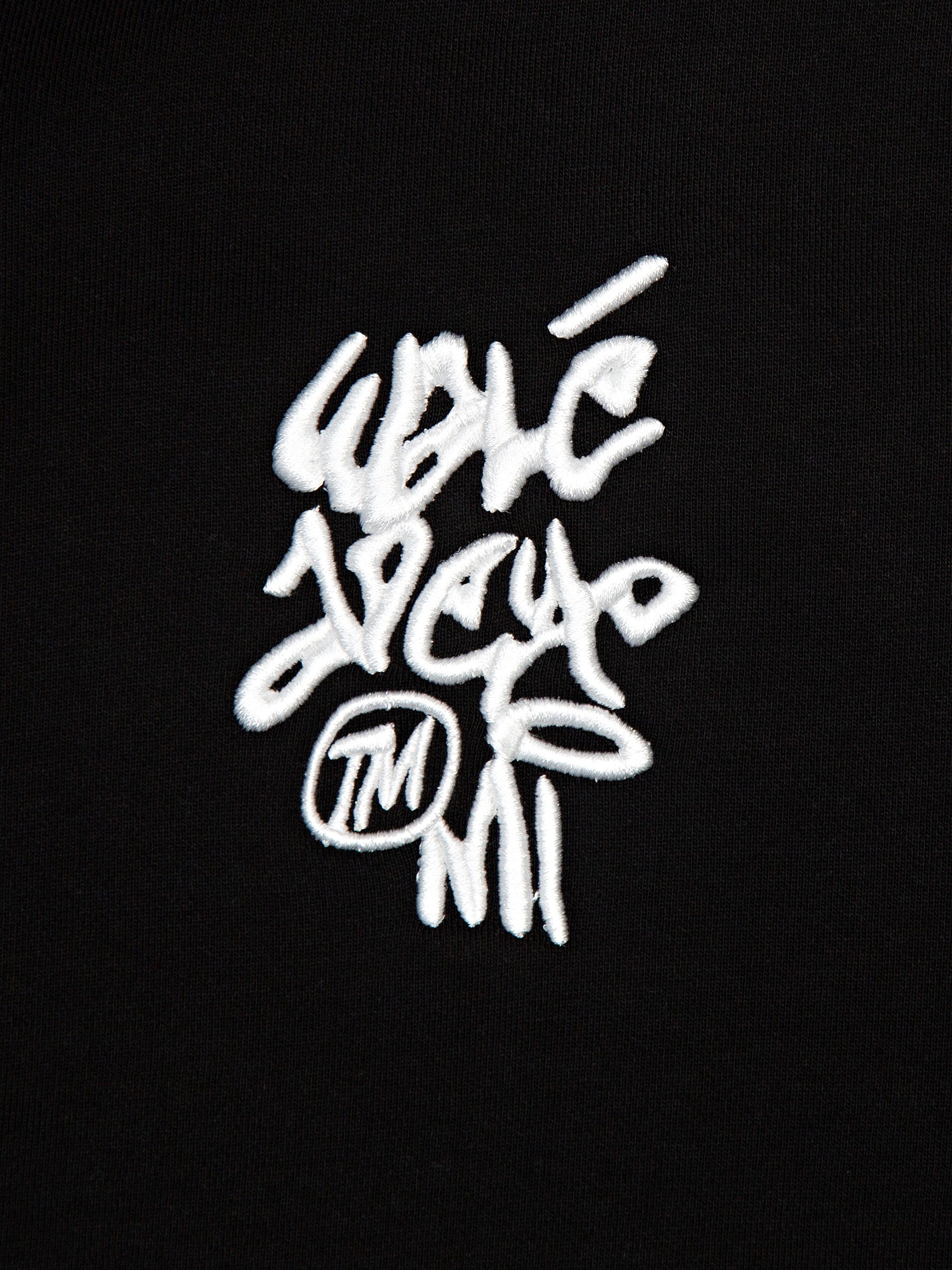 Close-up of the raised graffiti logo embroidery on the Walé Adeyemi Vinnie full-zip hoodie in Black/White