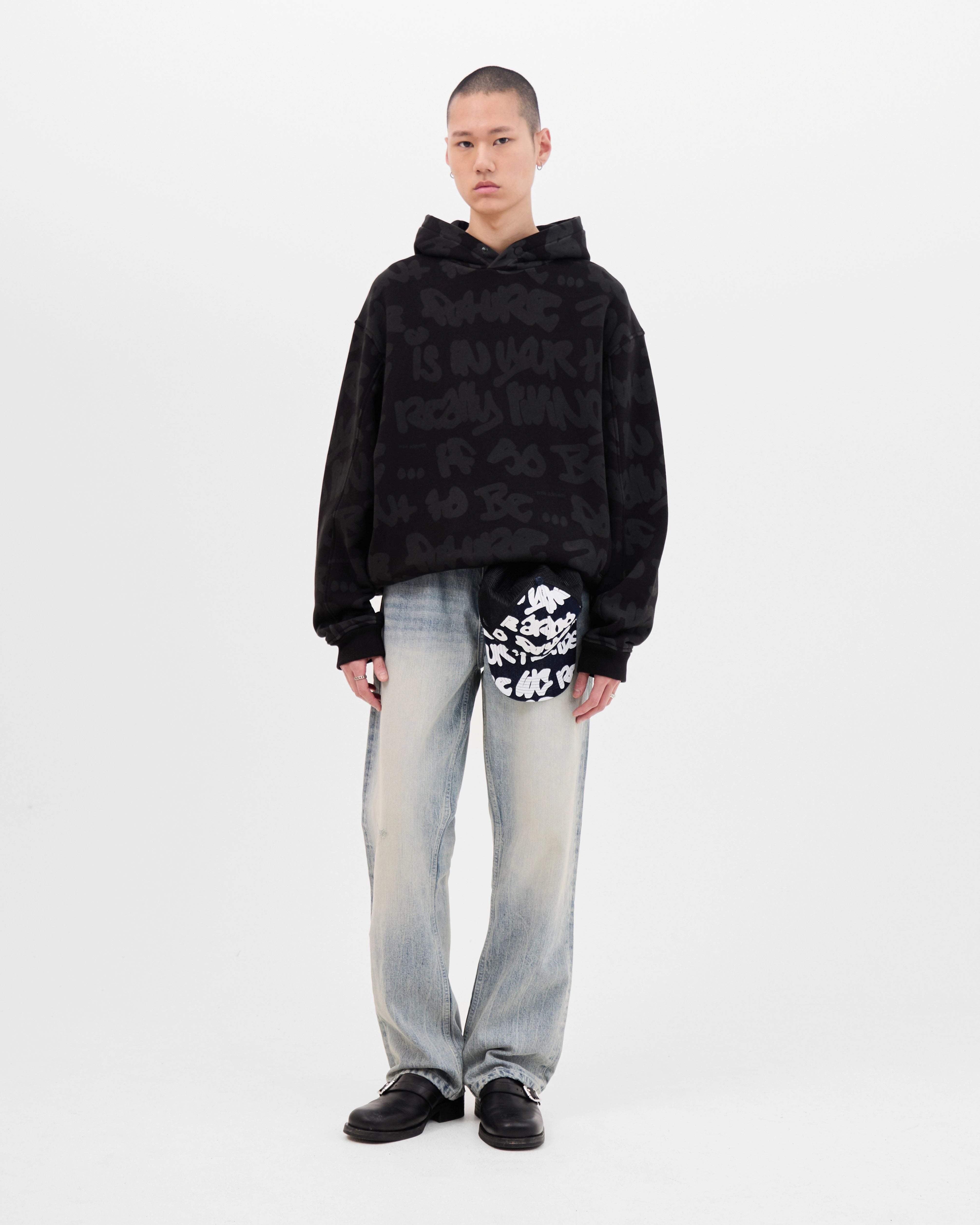 Model wearing the Walé Adeyemi AOP Graf Hood in Black, full front view