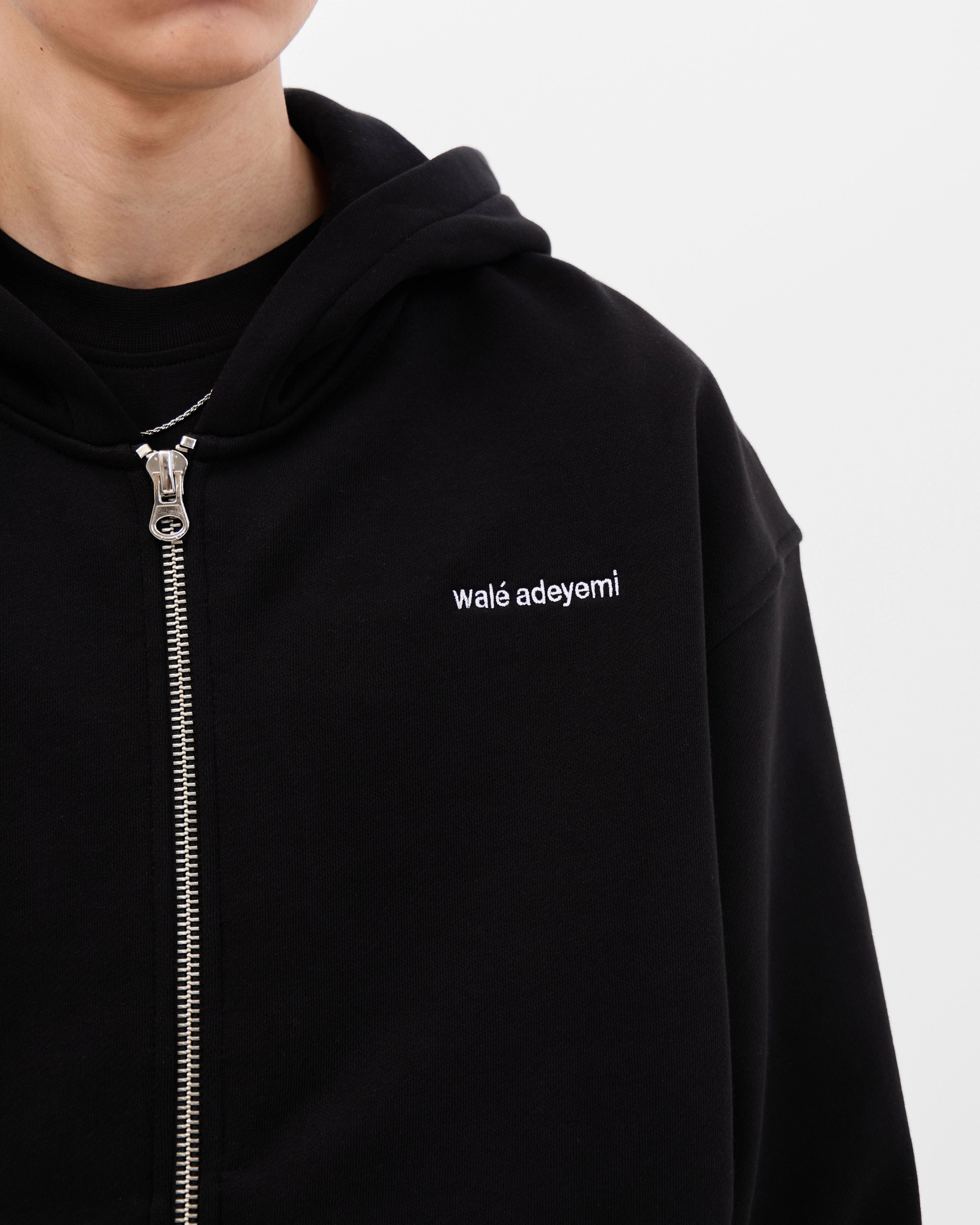 Close-up of the chest logo on the Walé Adeyemi Bridge Hoodie in Black/White