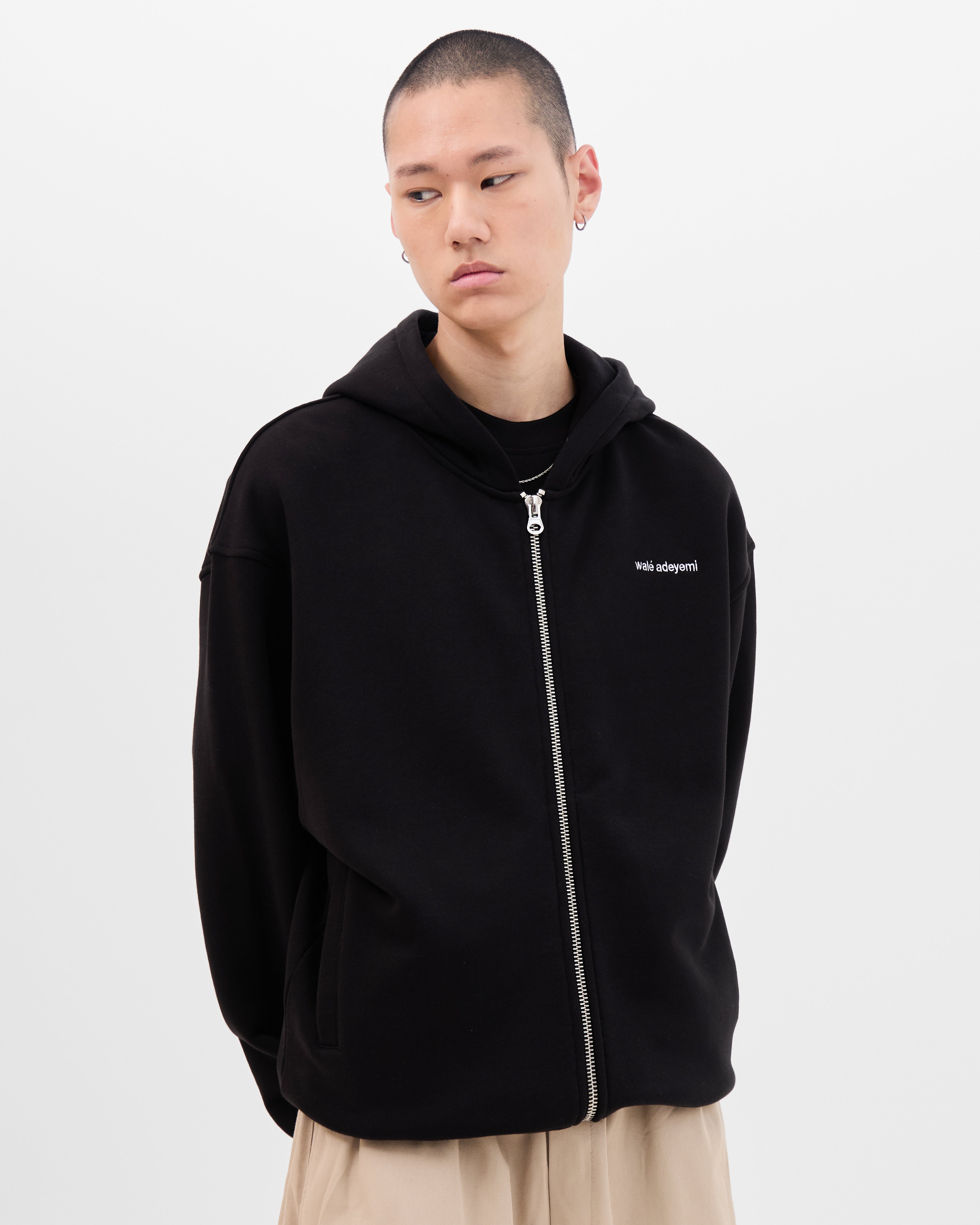 Model wearing the Walé Adeyemi Bridge full-zip hoodie in Black/White, relaxed fit, front view