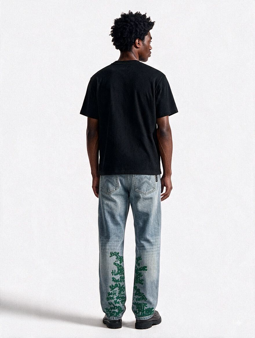 LP Custom Denim Jeans – Green worn from the back with a black tee, green Broken Hendrix print running up both hems — By Walé Adeyemi
