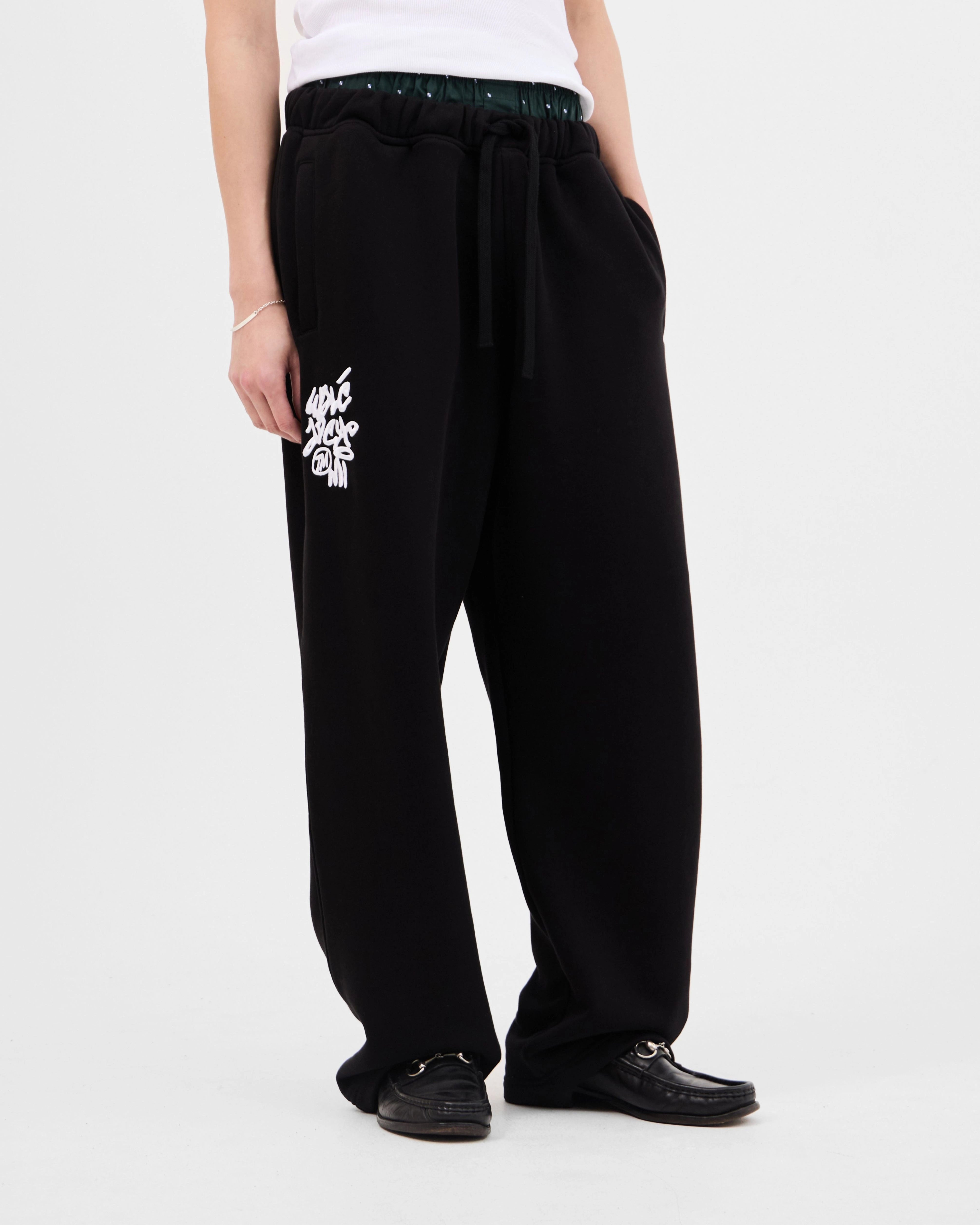 Model wearing the Walé Adeyemi Vinnie Joggers in Black/White, relaxed wide fit with drawstring waist, front view