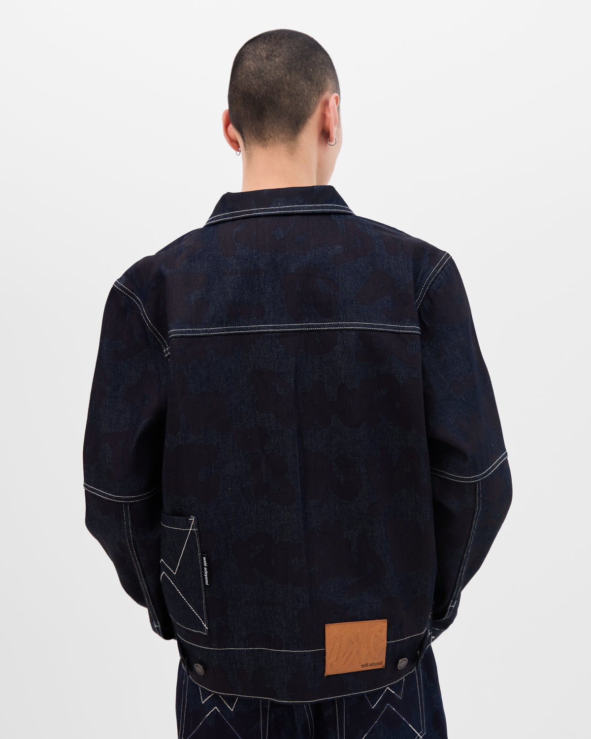 Back view of model wearing dark blue denim jacket by Wale Adeyemi