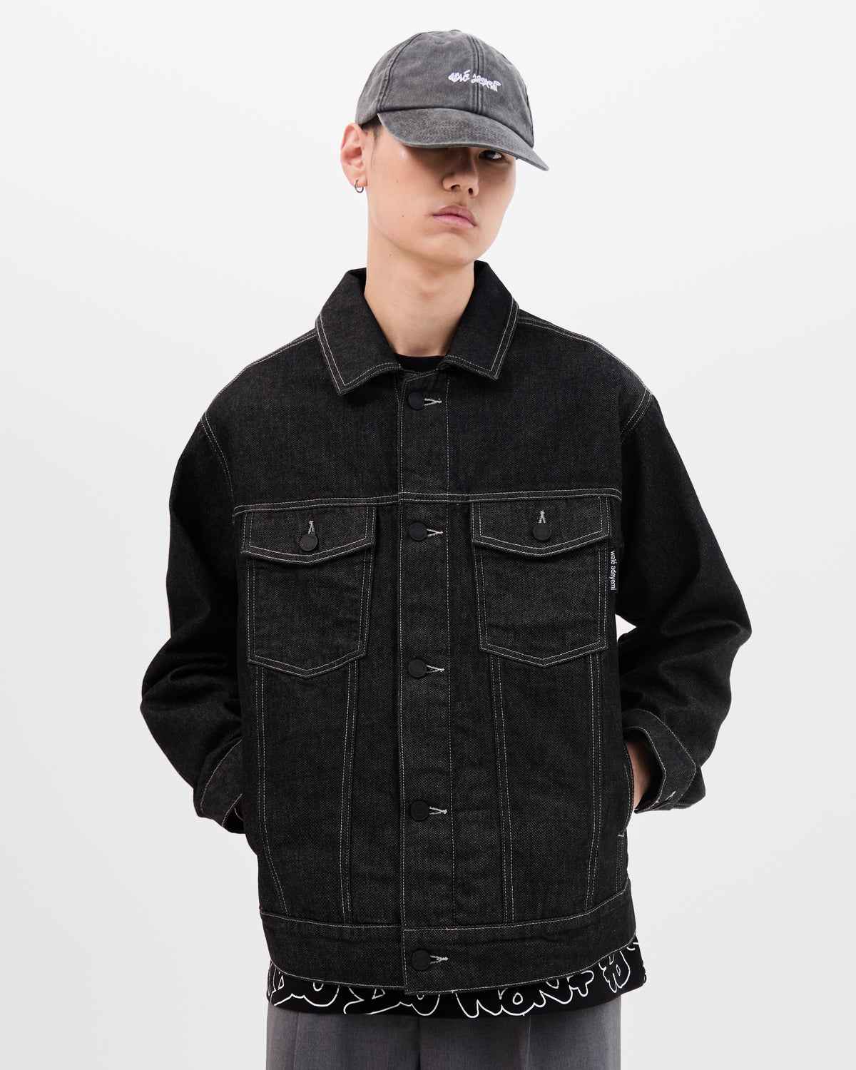 Model wearing a black denim jacket with baseball cap by Wale adeyemi