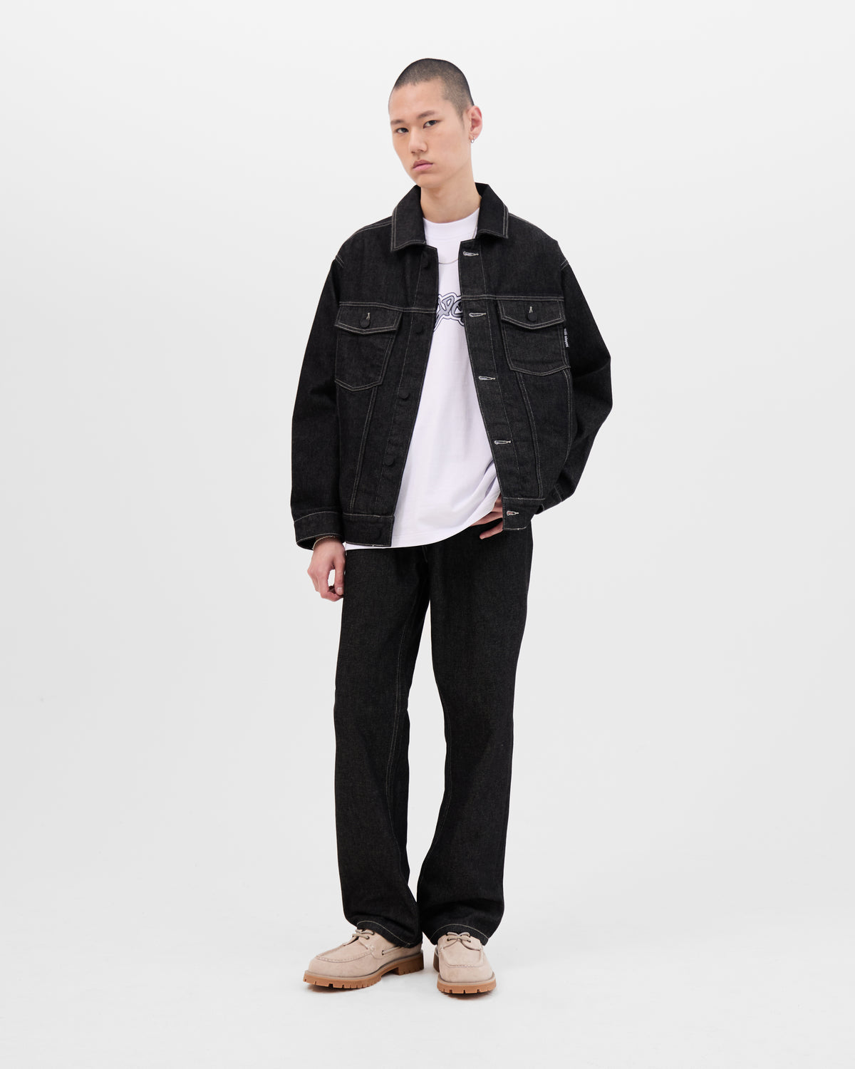 Model wearing the Walé Adeyemi Midnight Graf Denim Jacket in Black open over a white T-shirt, with the matching black jeans