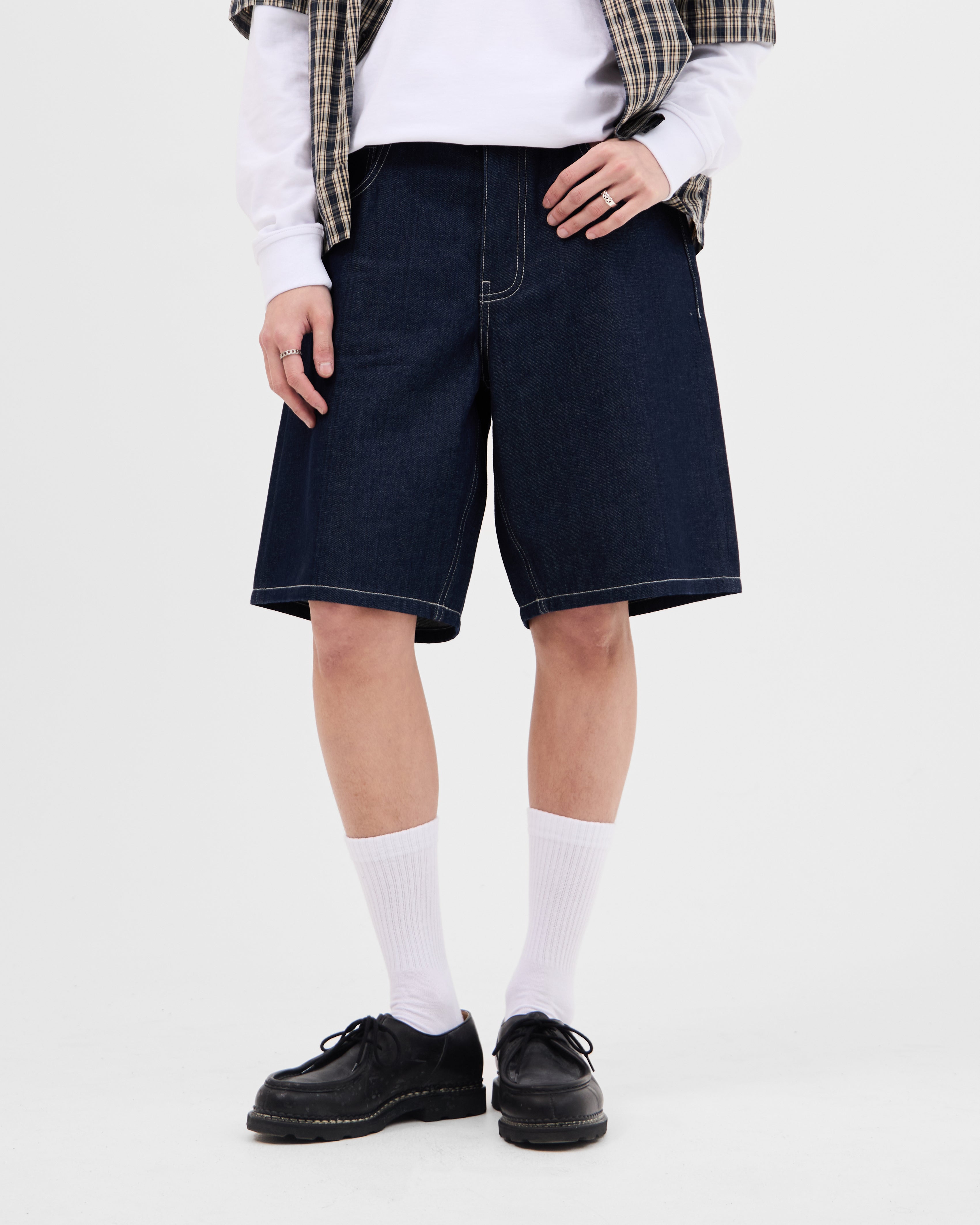 Model wearing the Walé Adeyemi Archive Graf Denim Shorts in Navy/Lemon, front view styled with a check shirt