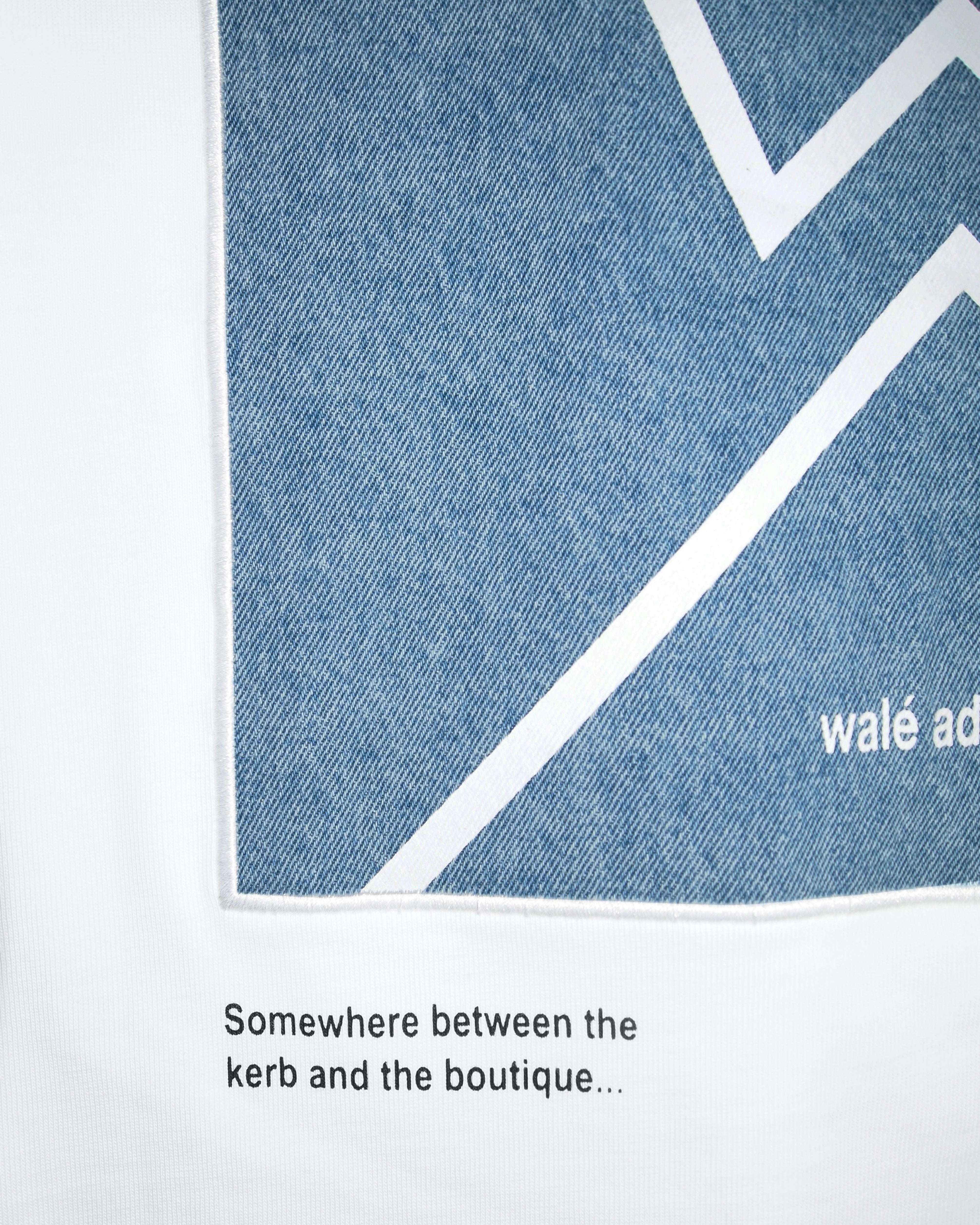 Close-up of the patch text on the Walé Adeyemi Backbeat long-sleeve T-shirt in White/Blue
