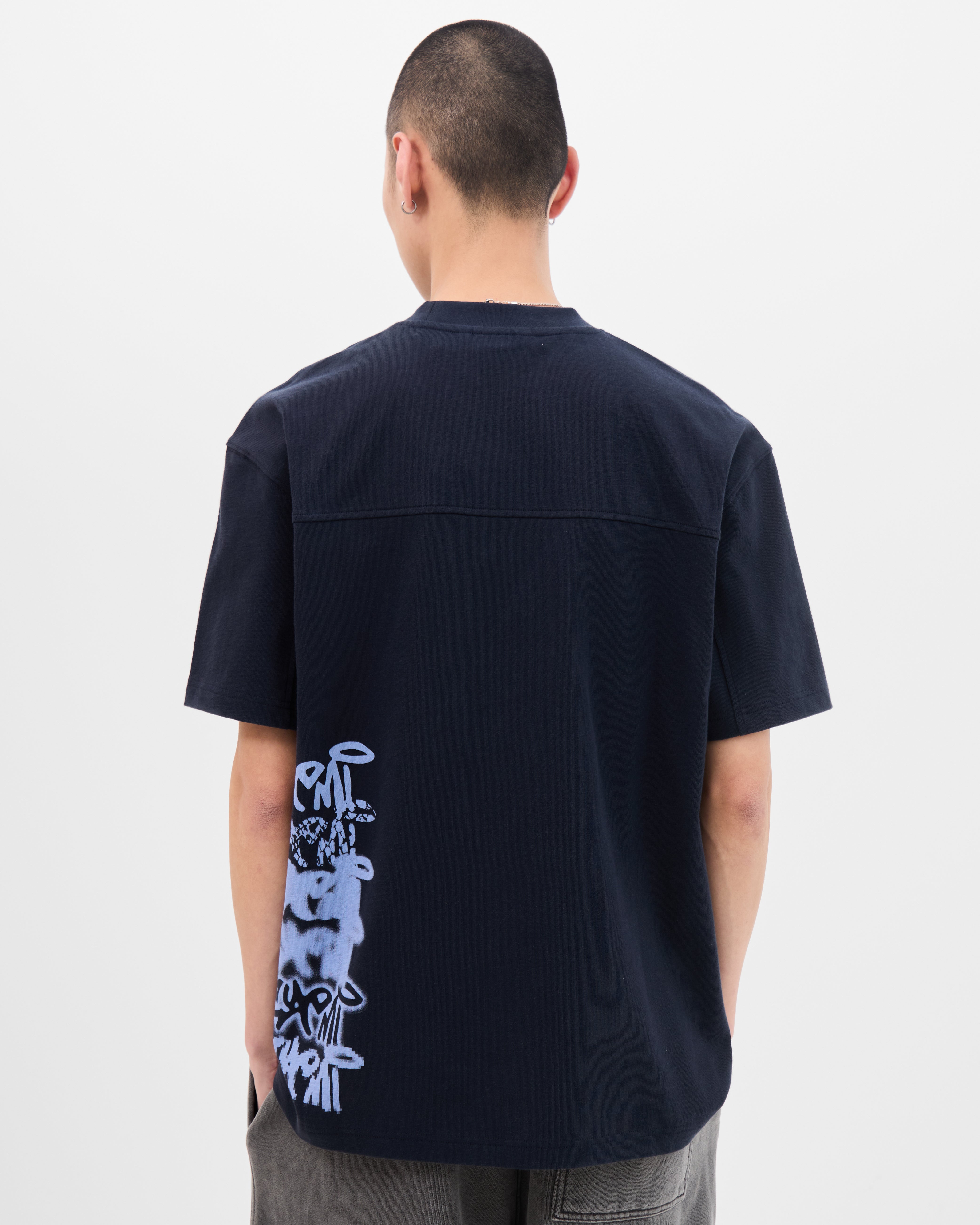 Model wearing the Walé Adeyemi Column T-shirt in Blue/Light Blue, back view showing the graffiti side print