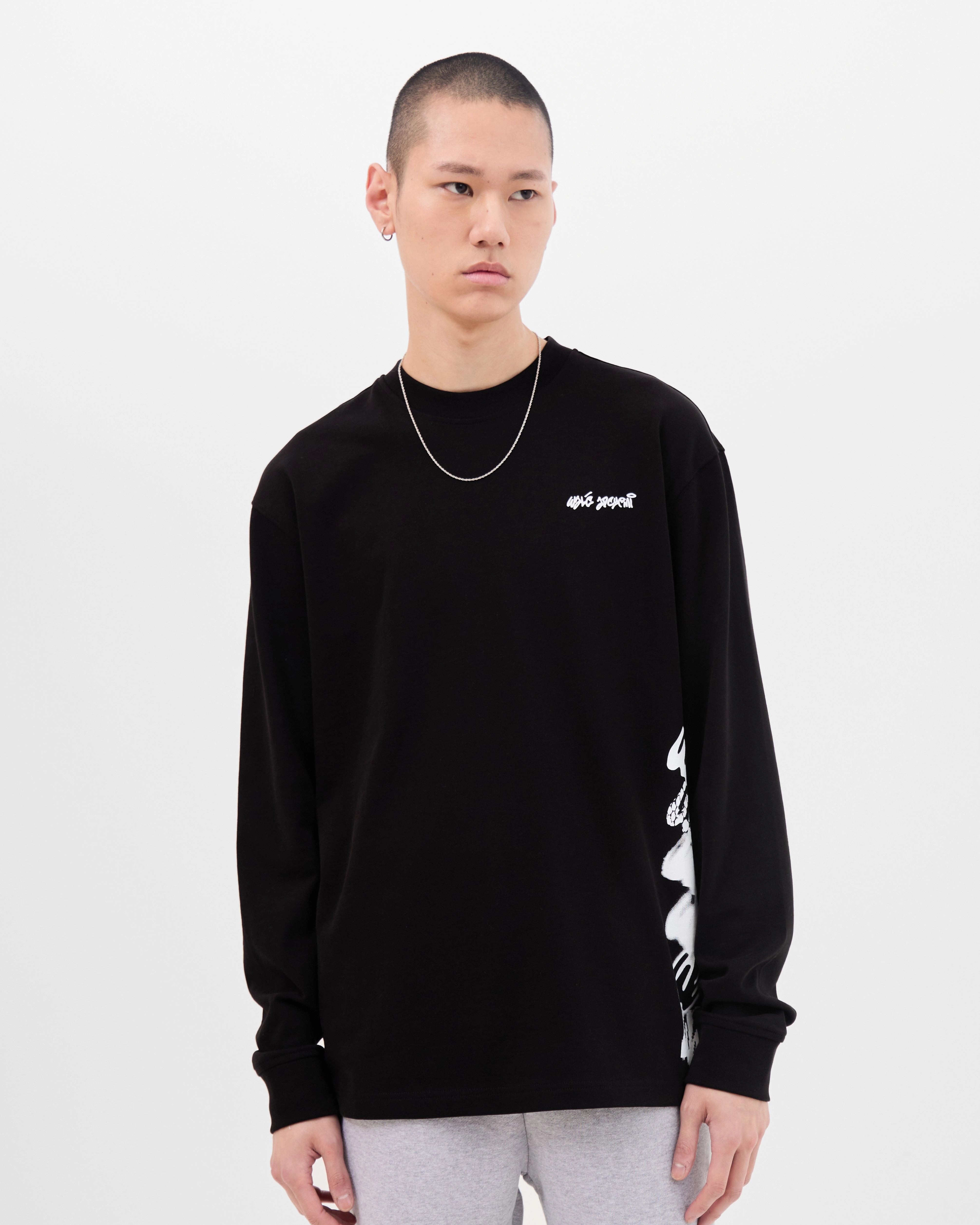 Model wearing the Walé Adeyemi Column long-sleeve T-shirt in Black/White, front view