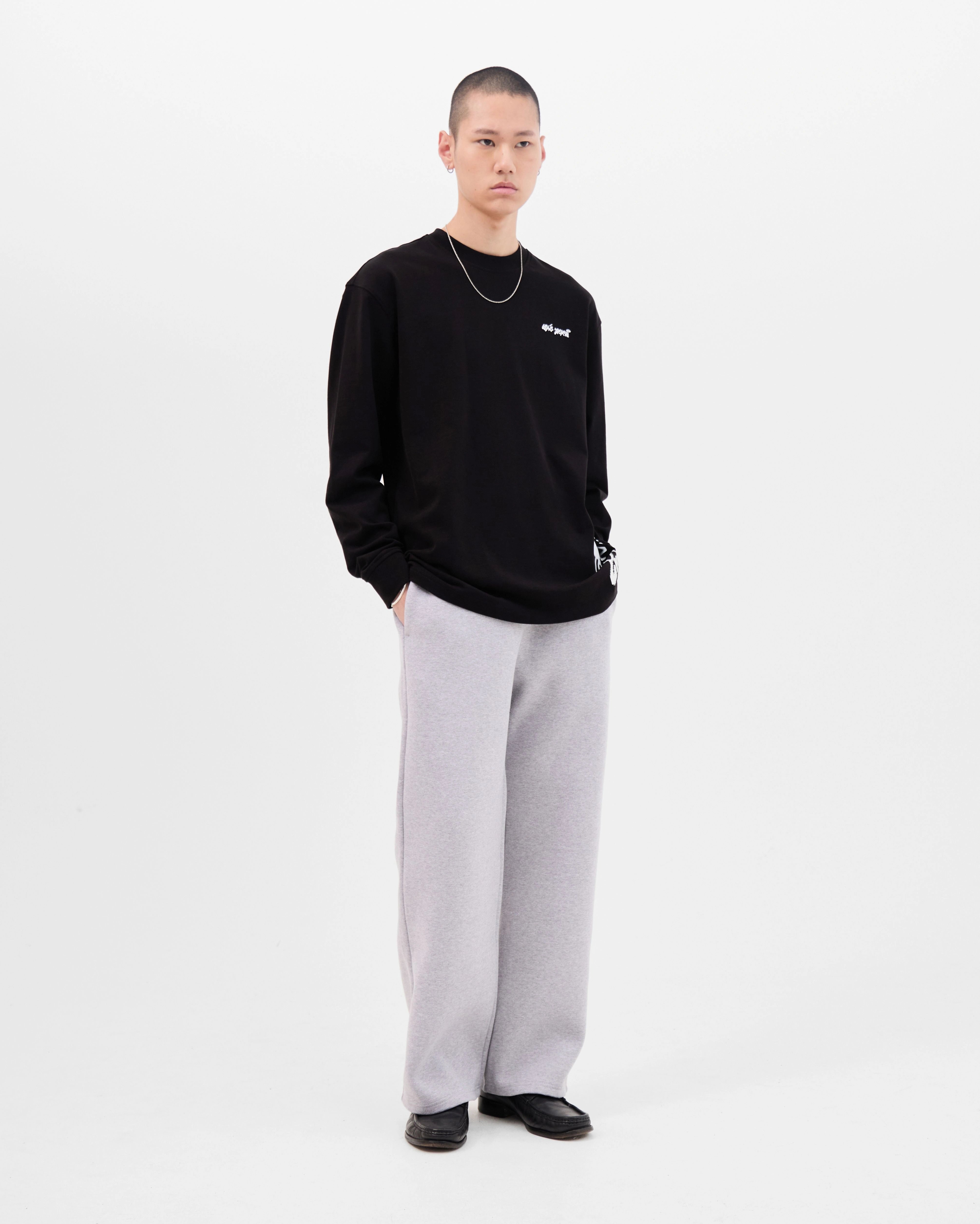 Model wearing the Walé Adeyemi Column long-sleeve T-shirt in Black/White, full front view