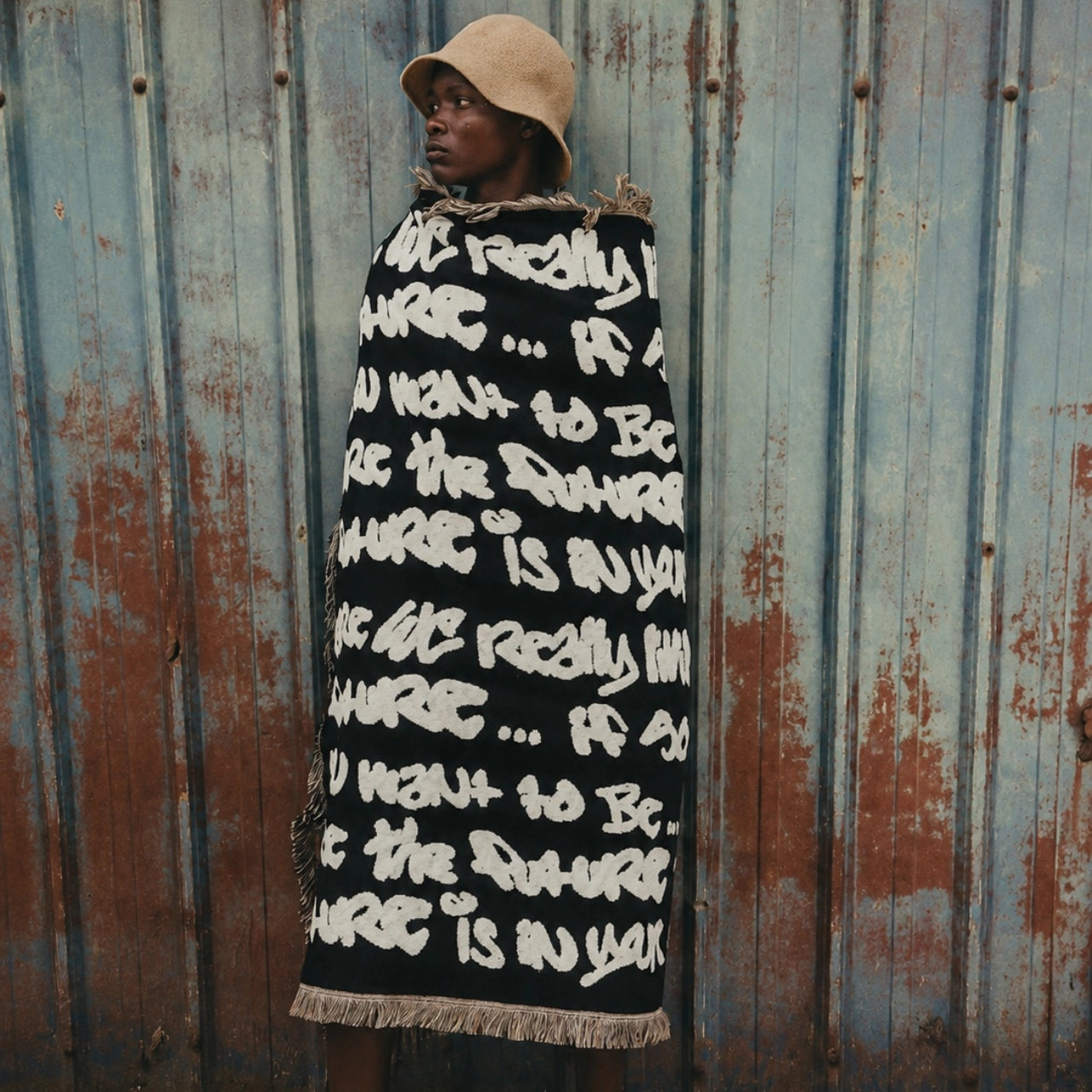 Walé Adeyemi model wrapped in black graffiti throw blanket