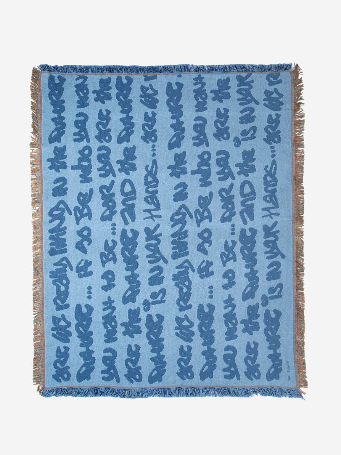 Graf Woven Throw close-up showing jacquard weave, graphic lettering and blue fringe