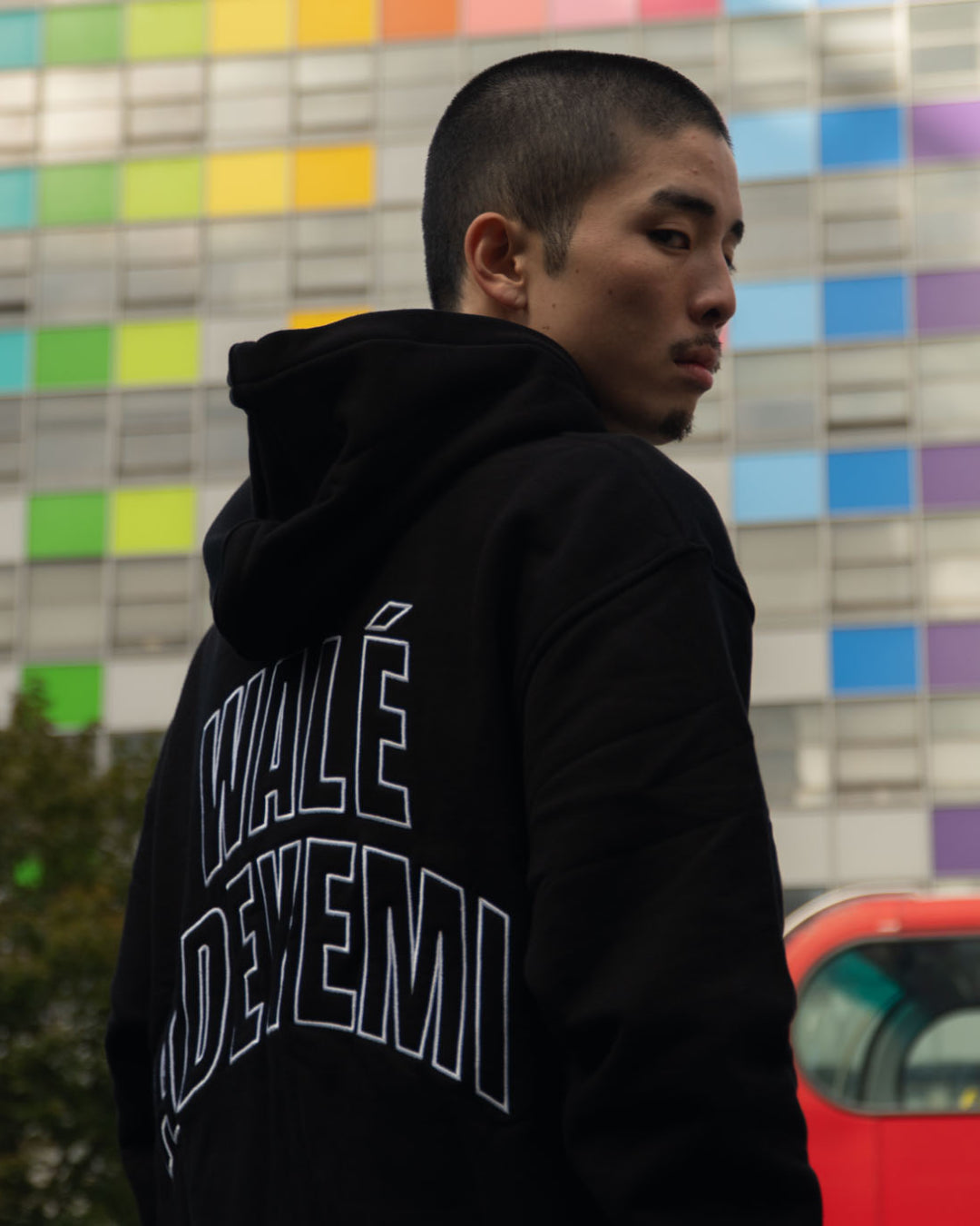 Model wearing a black hoodie with a Wale Adeyemi print on the back, mobile banner